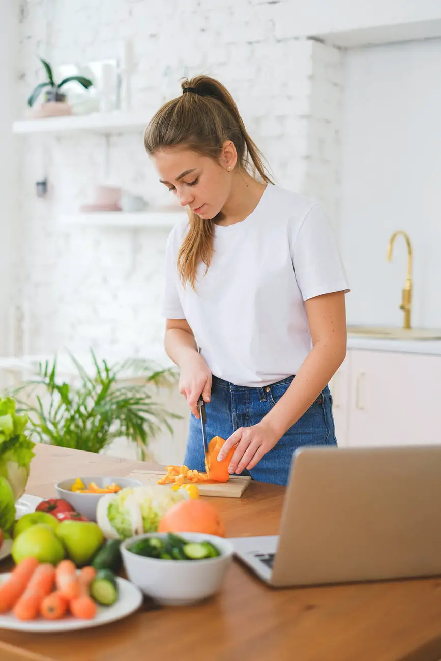 woman slicing a vegetable on chopping board